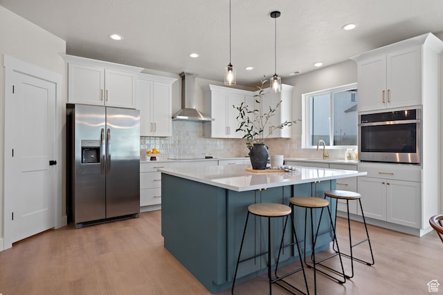 1324 E 320 S, Payson, UT 84651 - kitchen featuring appliances with stainless steel finishes, wall chimney exhaust hood, light wood-style floors, white cabinetry, and tasteful backsplash