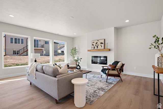 1324 E 320 S, Payson, UT 84651 - living room featuring wood finished floors, healthy amount of natural light, recessed lighting, a glass covered fireplace, and a textured ceiling