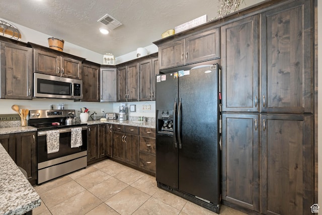140 W Center St Unit 29, Ivins, UT 84738 - kitchen with stainless steel appliances, dark brown cabinetry, light tile patterned floors, and light stone countertops