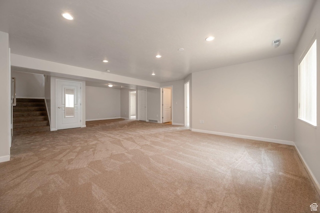 10056 S Remembrance Ln, South Jordan, UT 84095 - unfurnished living room with light colored carpet, stairway, recessed lighting, and healthy amount of natural light