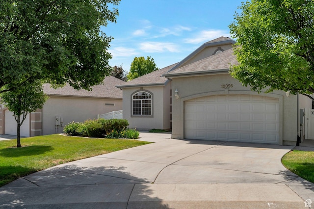 10056 S Remembrance Ln, South Jordan, UT 84095 - view of front of home with stucco siding, concrete driveway, a front lawn, a garage, and roof with shingles