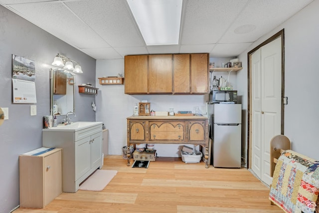 501 N Main St, Vernon, UT 84080 - kitchen with freestanding refrigerator, open shelves, a paneled ceiling, light wood-type flooring, and light countertops
