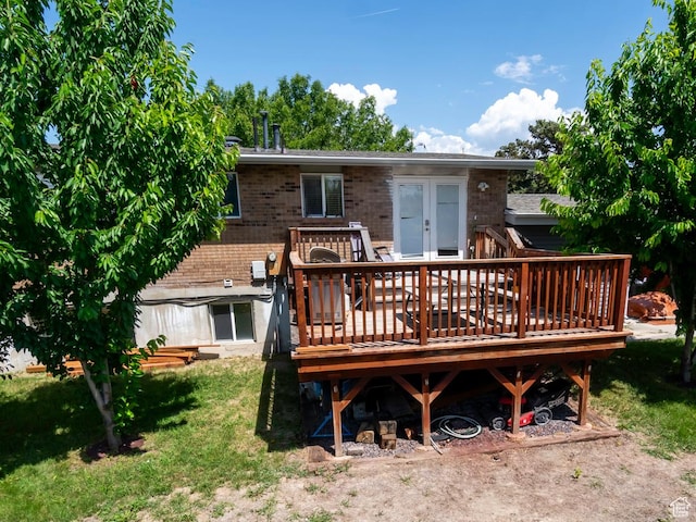 2970 S Mock Orange Dr W, West Valley City, UT 84119 - back of property with a deck, brick siding, french doors, and a lawn