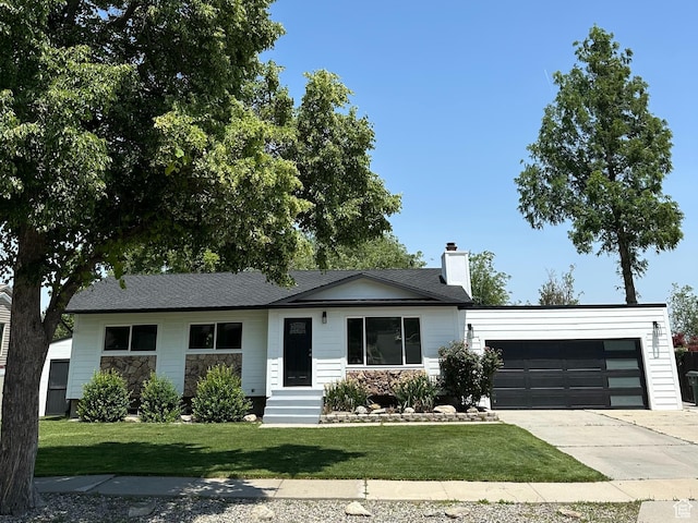 6306 W 3705 S, West Valley City, UT 84128 - view of front of property with stone siding, an attached garage, concrete driveway, a front yard, and a chimney