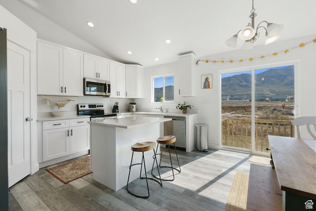4082 N Poplar Dr, Eagle Mountain, UT 84005 - kitchen featuring stainless steel appliances, a kitchen island, a mountain view, a kitchen breakfast bar, and white cabinets