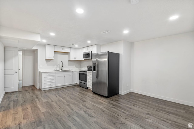 7335 N Harvest Crop Dr, Eagle Mountain, UT 84005 - kitchen featuring appliances with stainless steel finishes, wood finished floors, recessed lighting, white cabinets, and light countertops