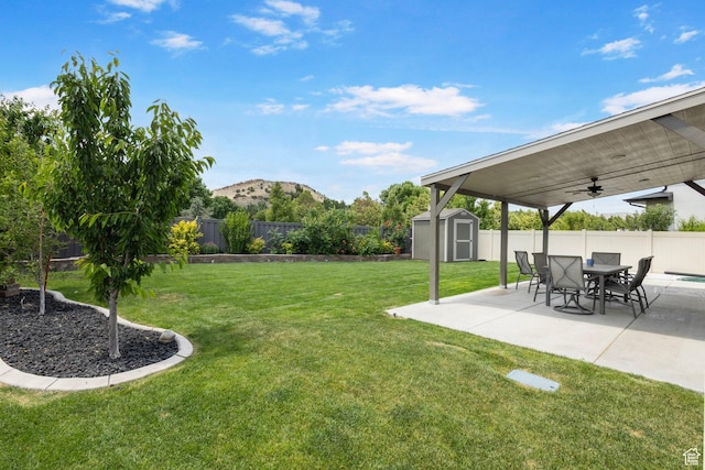 7335 N Harvest Crop Dr, Eagle Mountain, UT 84005 - fenced backyard with a storage unit, ceiling fan, a patio, and a mountain view