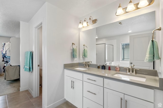 7335 N Harvest Crop Dr, Eagle Mountain, UT 84005 - full bathroom with a textured ceiling, double vanity, a stall shower, and tile patterned flooring