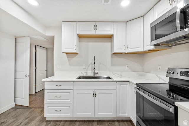 7335 N Harvest Crop Dr, Eagle Mountain, UT 84005 - kitchen featuring stainless steel appliances, white cabinets, wood finished floors, recessed lighting, and light stone countertops