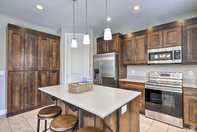 615 W 470 N, Moab, UT 84532 - kitchen featuring stainless steel appliances, a breakfast bar area, light tile patterned floors, light countertops, and a kitchen island