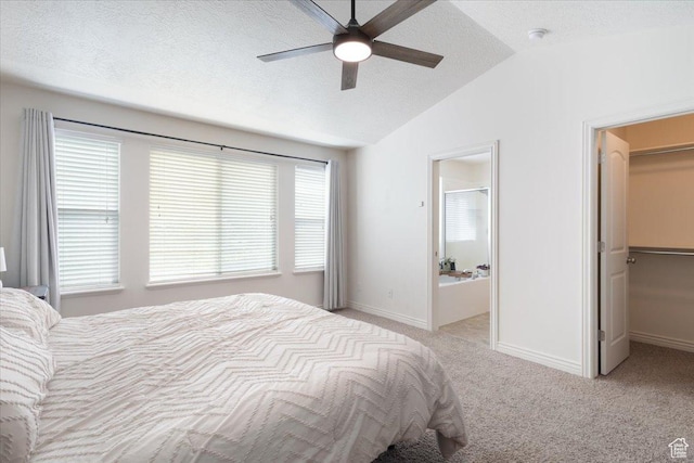 4509 S Greystock Cir W, West Valley City, UT 84120 - bedroom with lofted ceiling, a walk in closet, light colored carpet, a textured ceiling, and connected bathroom