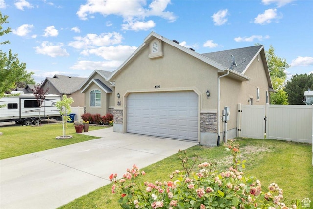 4509 S Greystock Cir W, West Valley City, UT 84120 - view of front of house featuring a garage, stucco siding, a gate, stone siding, and concrete driveway