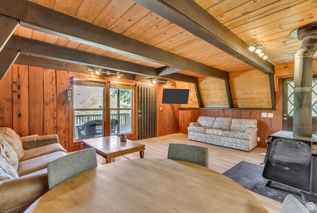 4601 Conifer Dr, Oakley, UT 84055 - living room with a wood stove, a wooden ceiling with exposed beams, wooden walls, and wood finished floors