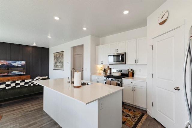 1010 E Bigelow Ave, Layton, UT 84040 - kitchen featuring appliances with stainless steel finishes, an island with sink, white cabinetry, light countertops, and dark wood-style flooring