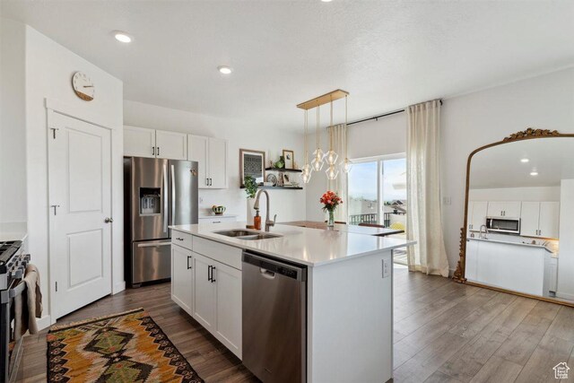 1010 E Bigelow Ave, Layton, UT 84040 - kitchen featuring stainless steel appliances, dark wood-type flooring, white cabinetry, light countertops, and a center island with sink