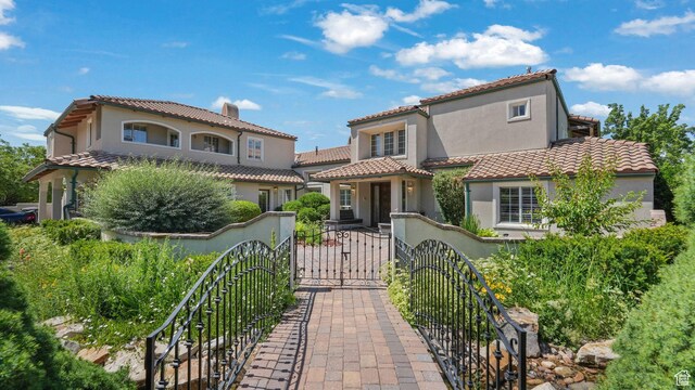 3175 N 140 W, Provo, UT 84604 - mediterranean / spanish-style house with a fenced front yard, stucco siding, a gate, and a tiled roof