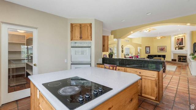 3175 N 140 W, Provo, UT 84604 - kitchen featuring black electric cooktop, double oven, ornate columns, arched walkways, and a peninsula