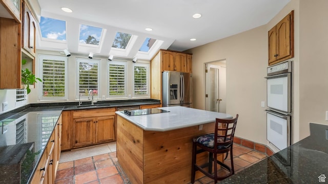 3175 N 140 W, Provo, UT 84604 - kitchen featuring stainless steel fridge, white double oven, a skylight, light tile patterned floors, and black electric cooktop