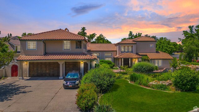 3175 N 140 W, Provo, UT 84604 - mediterranean / spanish home featuring an attached garage, driveway, a tiled roof, stucco siding, and a front lawn