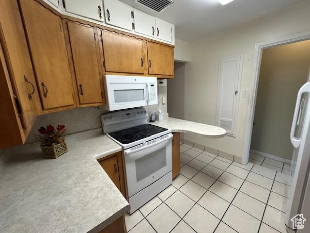 1567 E Westminster Ave, Salt Lake City, UT 84105 - kitchen with white appliances, light countertops, light tile patterned floors, and brown cabinets