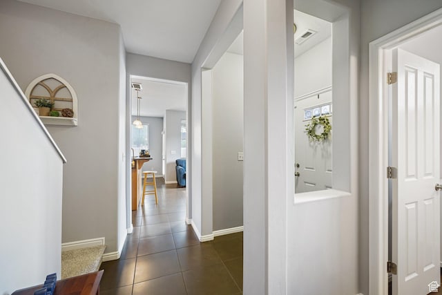 1051 W Castleton Dr, North Salt Lake, UT 84054 - hallway with plenty of natural light and dark tile patterned flooring