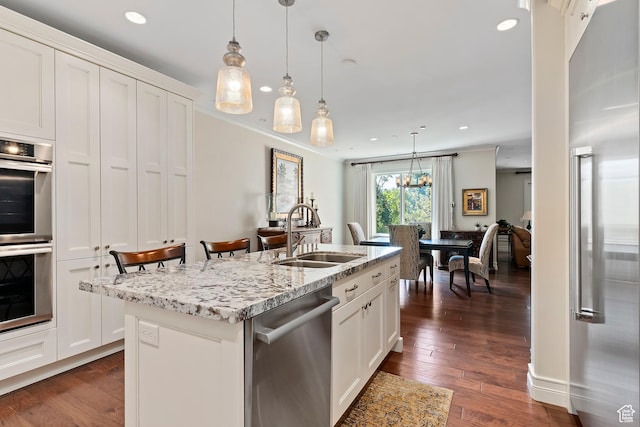 1706 E Murray Holladay Rd S Unit 204, Holladay, UT 84117 - kitchen with appliances with stainless steel finishes, dark wood-type flooring, hanging light fixtures, an island with sink, and white cabinets