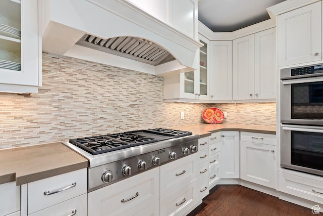 1706 E Murray Holladay Rd S Unit 204, Holladay, UT 84117 - kitchen featuring appliances with stainless steel finishes, custom range hood, white cabinetry, glass insert cabinets, and dark wood-style flooring