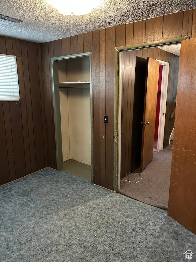 2784 W 2890 S, West Valley City, UT 84119 - unfurnished bedroom with carpet floors, wood walls, and a textured ceiling