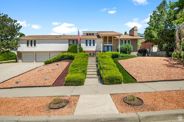771 E 17th Ave, Salt Lake City, UT 84103 - split level home featuring stairs, concrete driveway, a garage, and brick siding
