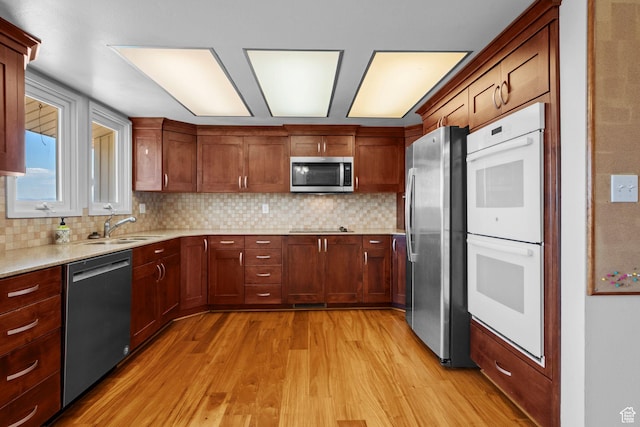771 E 17th Ave, Salt Lake City, UT 84103 - kitchen with appliances with stainless steel finishes, light wood-style flooring, and backsplash