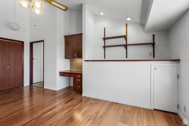 771 E 17th Ave, Salt Lake City, UT 84103 - empty room with light wood finished floors, high vaulted ceiling, a ceiling fan, built in desk, and a textured ceiling