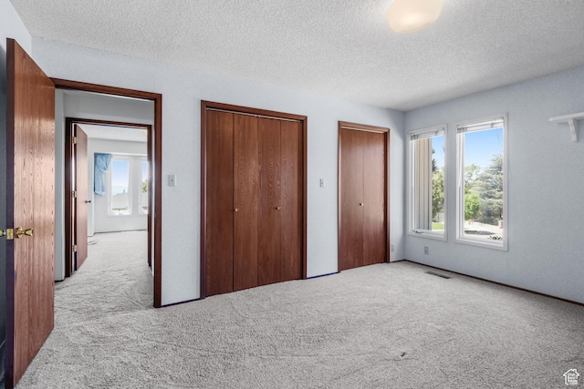 771 E 17th Ave, Salt Lake City, UT 84103 - unfurnished bedroom with carpet floors, multiple closets, and a textured ceiling