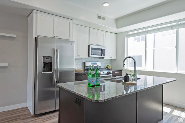 5306 W Solafax Ln, Herriman, UT 84096 - kitchen with appliances with stainless steel finishes, wood finished floors, white cabinetry, stone counters, and recessed lighting