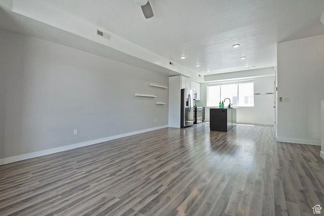 5306 W Solafax Ln, Herriman, UT 84096 - unfurnished living room with dark wood-style flooring, recessed lighting, and ceiling fan