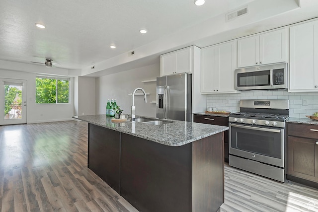 5306 W Solafax Ln, Herriman, UT 84096 - kitchen with appliances with stainless steel finishes, light wood-style flooring, light stone countertops, open floor plan, and recessed lighting
