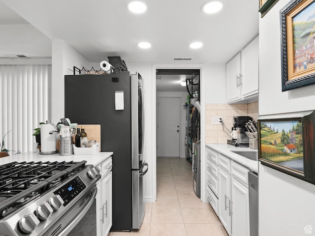 5423 S Tonalea Dr, Murray, UT 84107 - kitchen with light tile patterned floors, white cabinets, stainless steel appliances, decorative backsplash, and light countertops