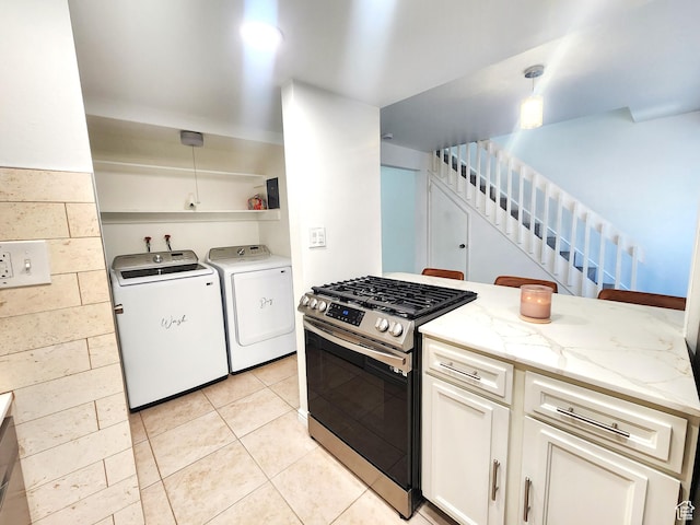 5423 S Tonalea Dr, Murray, UT 84107 - kitchen with stainless steel gas range, washer and clothes dryer, light stone counters, light tile patterned floors, and white cabinetry
