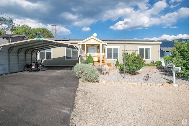 305 S Sheridan St, Stockton, UT 84071 - manufactured / mobile home featuring solar panels, a carport, and driveway