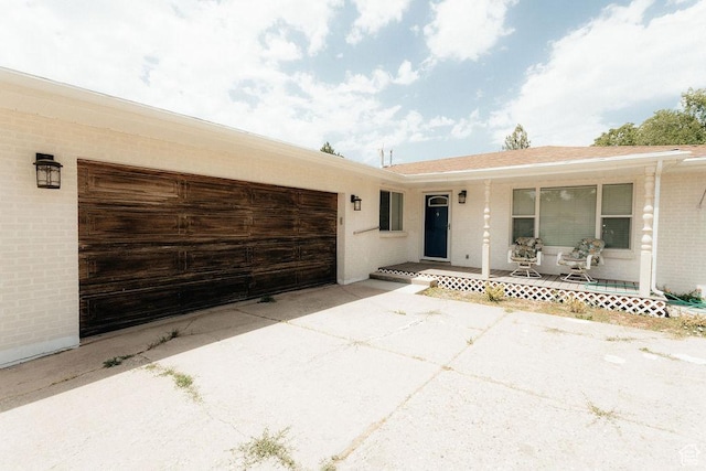 571 E Center St, Kaysville, UT 84037 - doorway to property with a porch, driveway, brick siding, and a garage