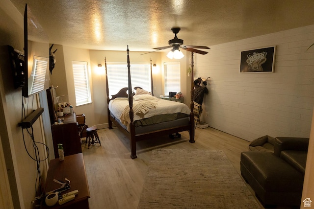 2673 S 2400 W, Weston, ID 83286 - bedroom with a textured ceiling, light wood finished floors, ceiling fan, and brick wall