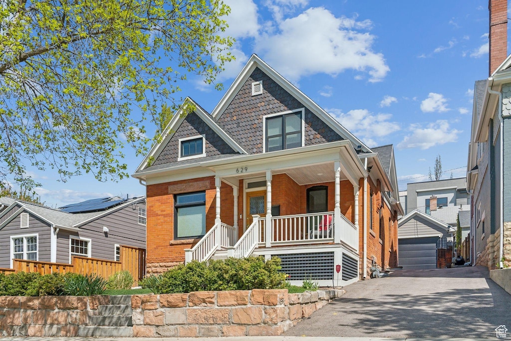 629 E Fifth Ave N, Salt Lake City, UT 84103 - victorian house with covered porch, an outdoor structure, brick siding, and a detached garage