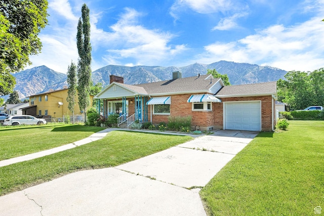 506 N 100 E, Brigham City, UT 84302 - ranch-style house featuring a mountain view, a front lawn, concrete driveway, and brick siding