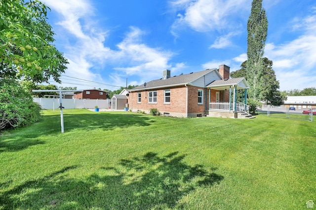 506 N 100 E, Brigham City, UT 84302 - back of house with brick siding, covered porch, a shed, and a fenced backyard