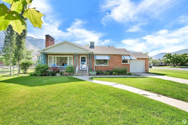506 N 100 E, Brigham City, UT 84302 - view of front of house with a mountain view, brick siding, covered porch, a garage, and driveway