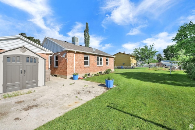 506 N 100 E, Brigham City, UT 84302 - rear view of property featuring a storage unit, brick siding, a yard, and a patio