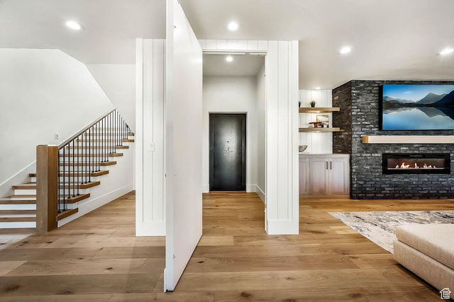 2225 Elk Meadows Cir, Woodland, UT 84036 - living room featuring stairs, wood finished floors, a glass covered fireplace, and recessed lighting