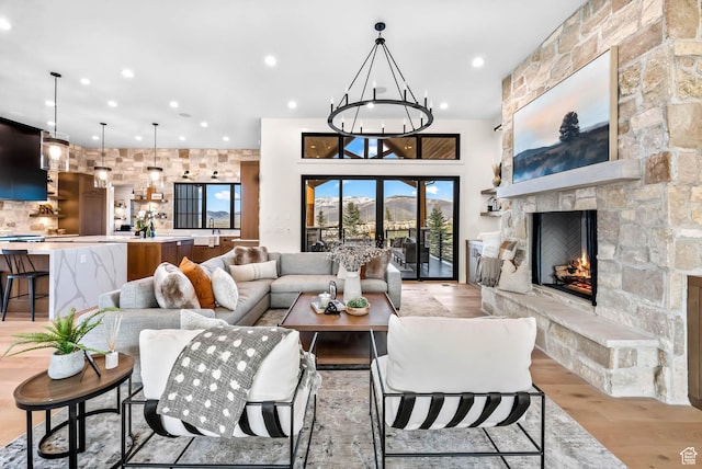 2225 Elk Meadows Cir, Woodland, UT 84036 - living room featuring light wood-style flooring, recessed lighting, a stone fireplace, and a chandelier