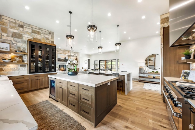 2225 Elk Meadows Cir, Woodland, UT 84036 - kitchen featuring wall chimney exhaust hood, a spacious island, open shelves, light wood finished floors, and beverage cooler