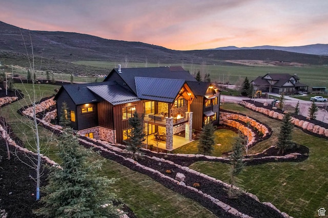 2225 Elk Meadows Cir, Woodland, UT 84036 - rear view of property featuring a mountain view, stone siding, a metal roof, a yard, and a standing seam roof