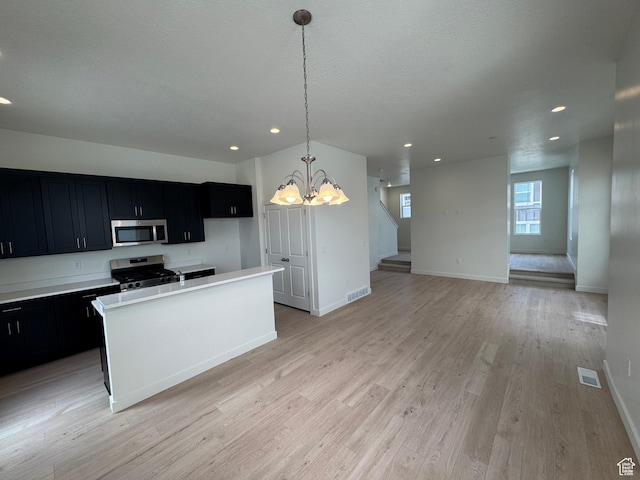 1668 N 1600 W Unit 128, Layton, UT 84041 - kitchen featuring stainless steel microwave, stove, dark cabinets, a chandelier, and recessed lighting
